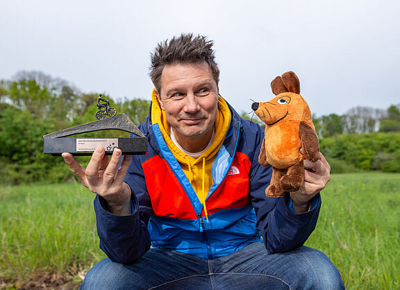 Moderator André Gatzke und die Maus mit der Auszeichnung Fahrradfreundlichste Persönlichkeit 2024.