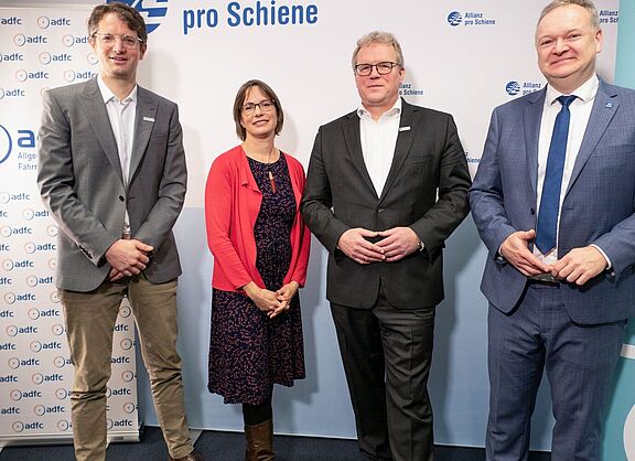 Vier Personen stehen vor hellem Hintergrund: Wasilis von Rauch, Geschäftsführer Zukunft Fahrrad, Ann-Kathrin Schneider, ADFC-Bundesgeschäftsführerin, Dirk Flege, Geschäftsführer der Allianz pro Schiene und Burkhard Stork, Geschäftsführer des Zweirad-Industrie-Verbands (v.l.n.r.).  