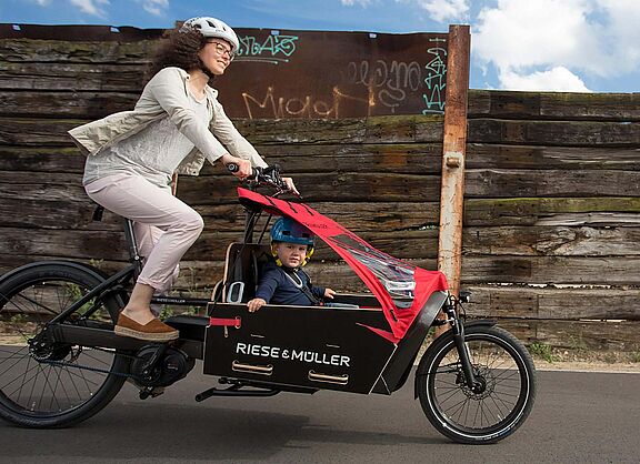 Mutter und Kind mit dem E-Bike Lastenrad unterwegs
