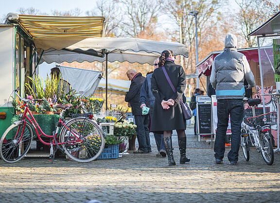 Marktszene mit Fußgängern und geparkten Fahrrädern