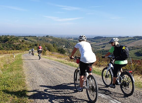 Zwei Frauen auf Fahrrädern in hügeliger Landschaft