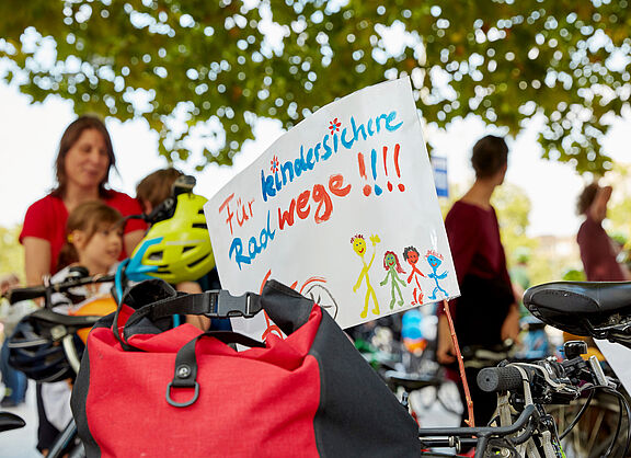 Demoschild, das sichere Radwege für Kinder fordert