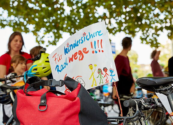 Demoschild, das sichere Radwege für Kinder fordert
