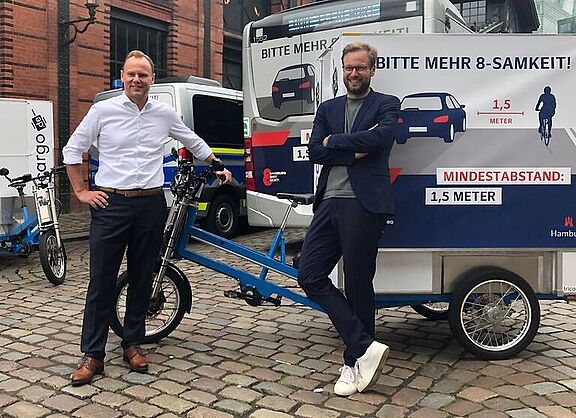Verkehrssenator Anjes Tjarks und Innensenator Andy Grote vor dem neuen Kampagnenmotiv