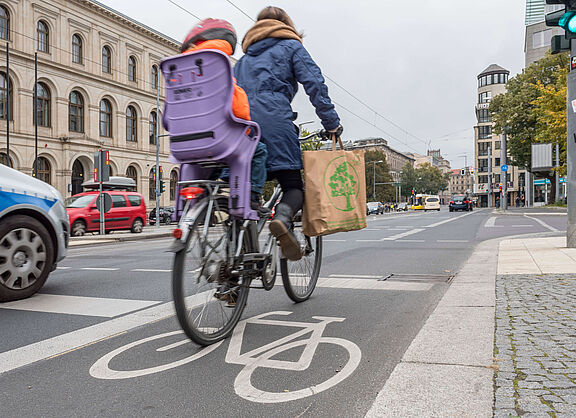 Frau mit Kind auf dem Rad in der Stadt unterwegs