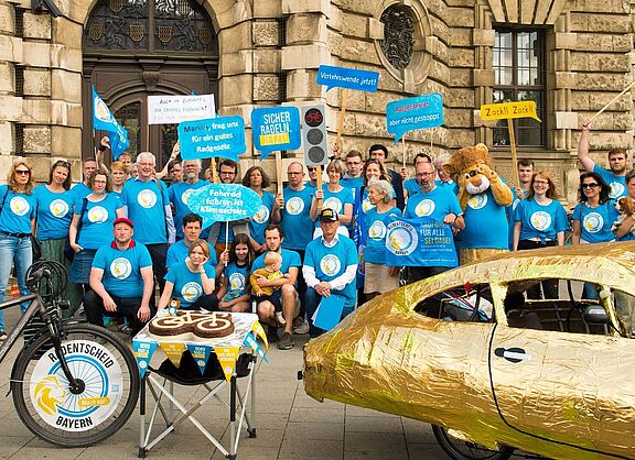 Eine Gruppe Radentscheid-Aktivist:innen vor dem Bayerischen Verfassungsgerichts-Gebäude in blauen T-Shirts. 