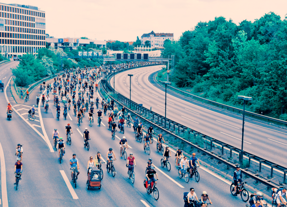 Bloick von oben auf eine Autobahn mit zahlreichen Radfahrenden. 