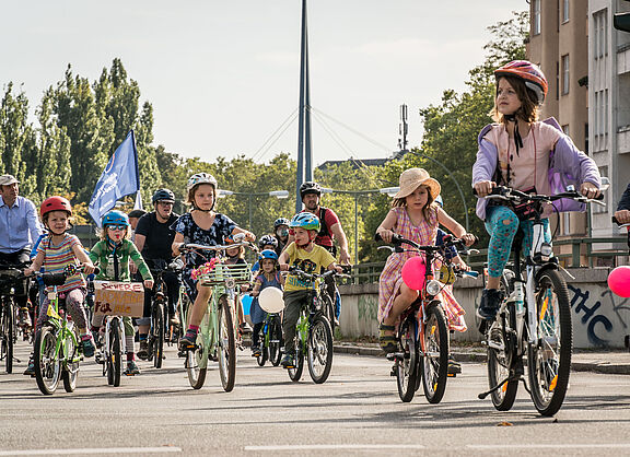 zahlreiche Kinder auf Fahrrädern mit Luftballons und Fahnen in Berlin